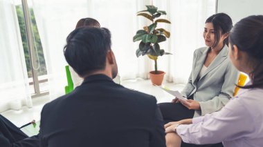 İş adamları daire içinde otururken iş projesini ustaca tartışıyor