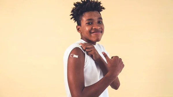 Afrikansk amerikansk tonåring visar COVID-19 vaccin bandage glatt — Stockfoto