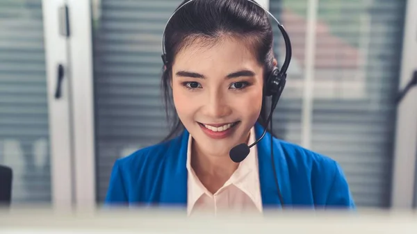 Mulher de negócios usando fone de ouvido trabalhando ativamente no escritório — Fotografia de Stock