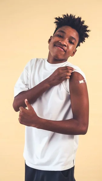 African American teenager showing COVID-19 vaccine bandage merrily — Stock Photo, Image