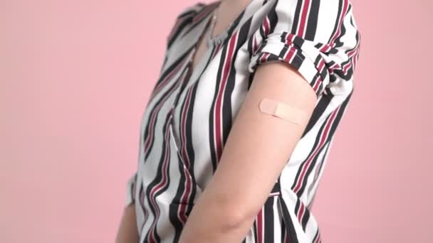 Ung kvinna som visar COVID-19 vaccinbandage glatt — Stockvideo