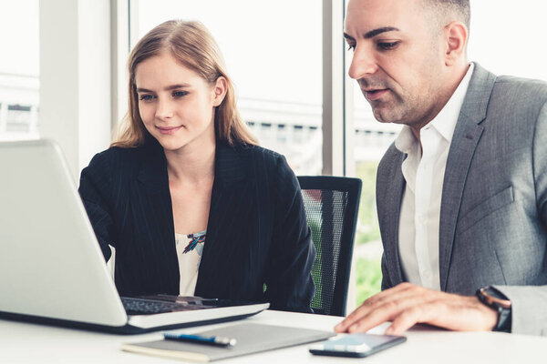 Businessman and businesswoman working in office.