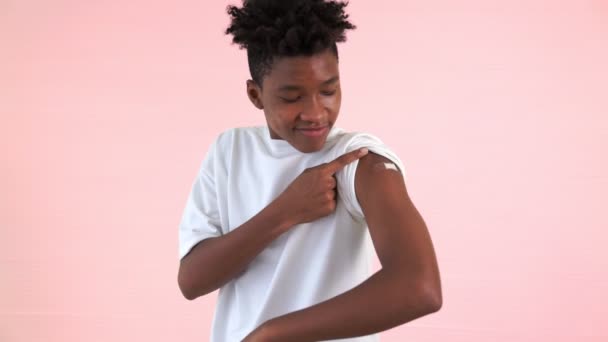 Afro-Amerikaanse tiener toont vrolijk COVID-19 vaccinverband — Stockvideo
