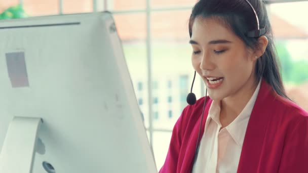 Mulher de negócios usando fone de ouvido trabalhando ativamente no escritório — Vídeo de Stock