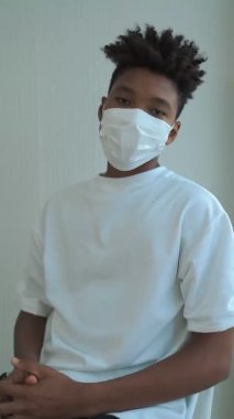 Genç Afrikalı adamın yüzünden maskesini çıkardığı dikey video.