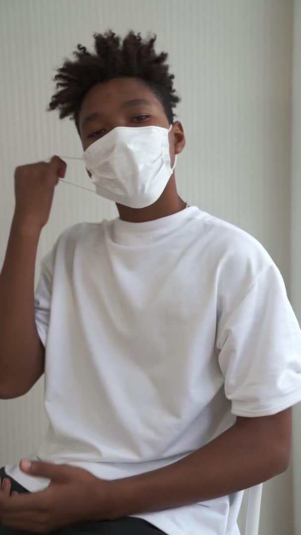 Pionowe nagranie młodego Afrykanina zdejmującego maskę twarzy z twarzy — Wideo stockowe