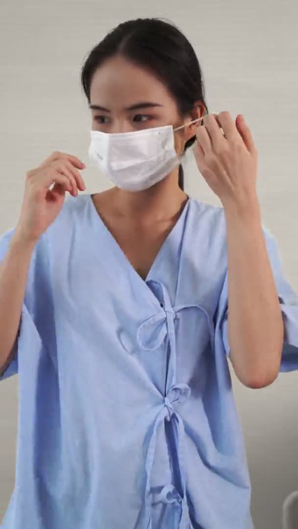 얼굴을 가리고 있는 마스크를 벗고 있는 젊은 아시아 여성의 모습 — 비디오