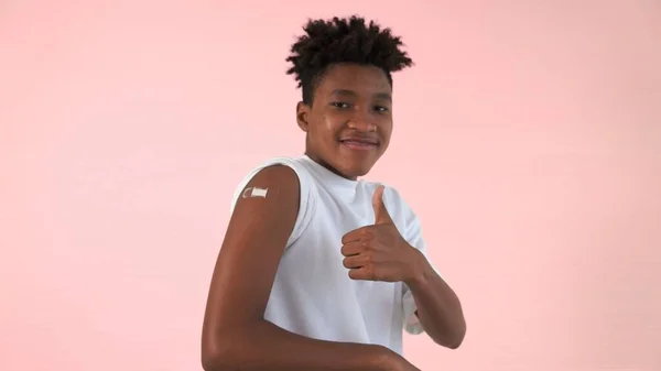 African American teenager showing COVID-19 vaccine bandage merrily — Stock Photo, Image