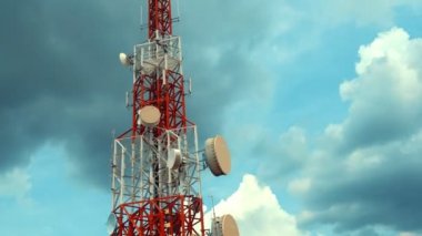 Gökyüzüne karşı büyük telekomünikasyon kulesi ve arka planda bulutlar