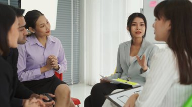 İş adamları daire içinde otururken iş projesini ustaca tartışıyor