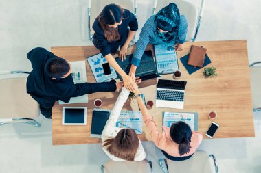 Takım çalışması çalışanları toplantıda el ele tutuşuyor.