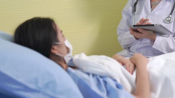 Médecin portant un masque facial parle avec compétence avec le patient à l'hôpital — Video