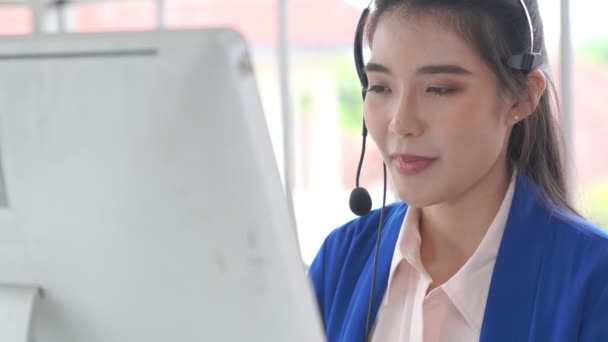 Επιχειρηματίας που φοράει ακουστικά και εργάζεται ενεργά στο γραφείο — Αρχείο Βίντεο