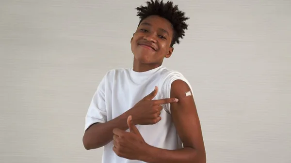 Afrikansk amerikansk tonåring visar COVID-19 vaccin bandage glatt — Stockfoto