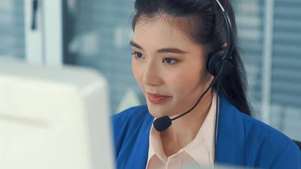 戴着耳机在办公室积极工作的女商人 — 图库照片