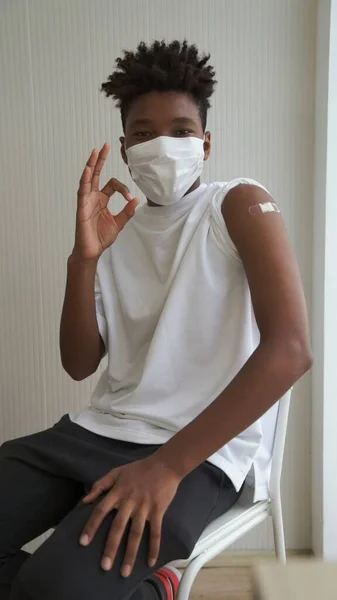 African American teenager showing COVID-19 vaccine bandage merrily — Stock Photo, Image