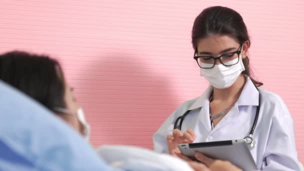 Médecin portant un masque facial parle avec compétence avec le patient à l'hôpital — Video