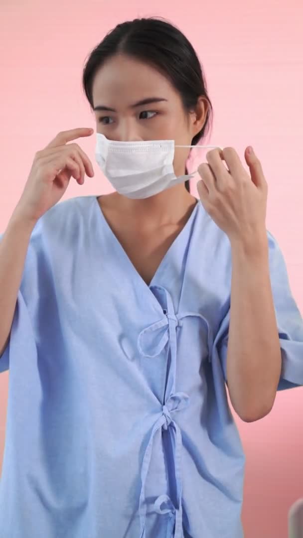 Vertical video of young Asian woman take off face mask removing from face — Stock Video