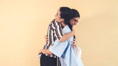 Mutlu arkadaşlar maskesini çıkarıp birbirlerine sıkıca sarılırlar.