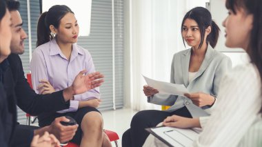 İş adamları daire içinde otururken iş projesini ustaca tartışıyor