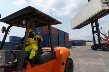 Tersanede forklift kullanan Afrikalı Amerikalı bir adam.