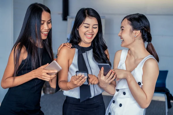 Tres mujeres amigos chatear con el dispositivo de teléfono móvil. —  Fotos de Stock