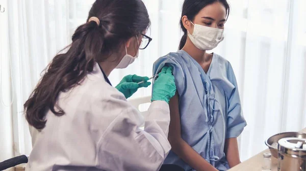 Молода жінка відвідує кваліфікованого лікаря в лікарні для вакцинації — стокове фото