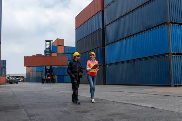 Промышленный рабочий работает с коллегами на зарубежной судоходной контейнерной верфи — стоковое фото