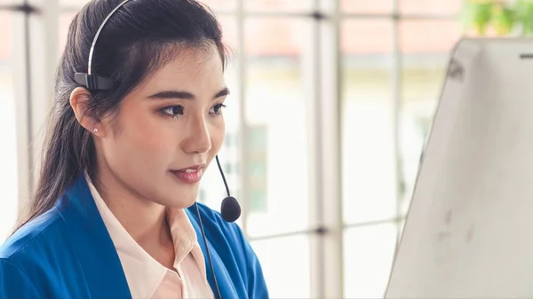 Empresaria con auriculares trabajando activamente en la oficina — Foto de Stock