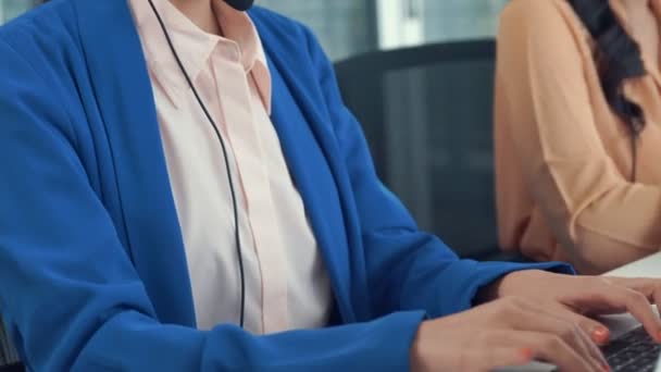 Mulher de negócios usando fone de ouvido trabalhando ativamente no escritório — Vídeo de Stock