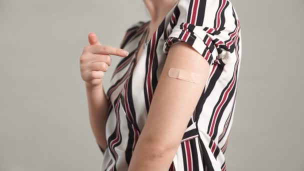 Mujer joven con vendaje de vacuna COVID-19 alegremente — Vídeo de stock