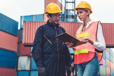 Endüstriyel işçiler, deniz aşırı nakliye konteynır sahasında iş arkadaşlarıyla çalışıyor.