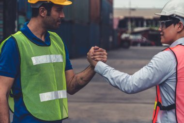 Endüstriyel işçiler, deniz aşırı nakliye konteynır sahasında iş arkadaşlarıyla çalışıyor.