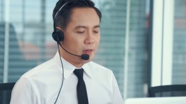 Kulaklık takan bir işadamı aktif olarak ofiste çalışıyor.