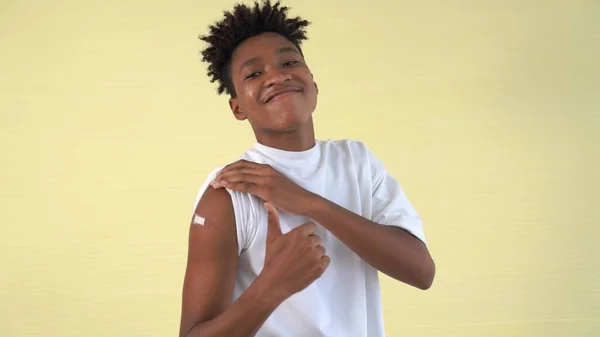 African American teenager showing COVID-19 vaccine bandage merrily — Stock Photo, Image