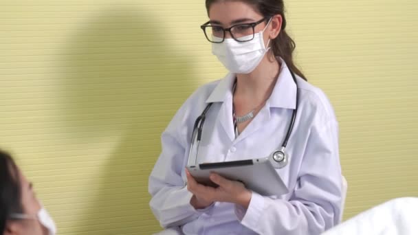 Médecin portant un masque facial parle avec compétence avec le patient à l'hôpital — Video