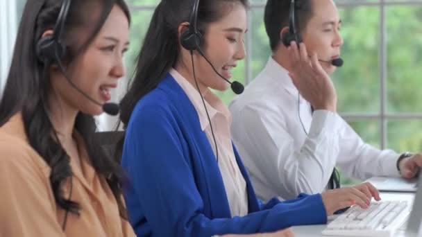Επιχειρηματίες που φορούν ακουστικά και εργάζονται ενεργά στο γραφείο — Αρχείο Βίντεο