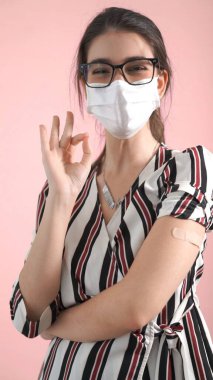 Genç kadın COVID-19 aşısını neşeyle sargılıyor.