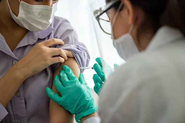 Young woman visits skillful doctor at hospital for vaccination