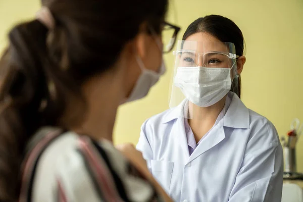 Молода жінка відвідує кваліфікованого лікаря в лікарні для вакцинації — стокове фото