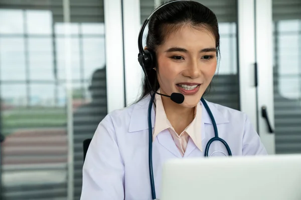 Medico indossando auricolare parlando attivamente in videochiamata in ospedale o in clinica — Foto Stock