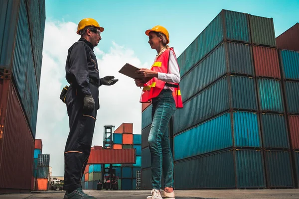 Industrial worker works with co-worker at overseas shipping container yard