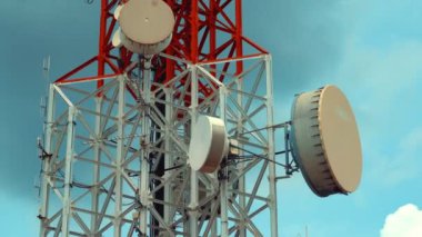 Gökyüzüne karşı büyük telekomünikasyon kulesi ve arka planda bulutlar