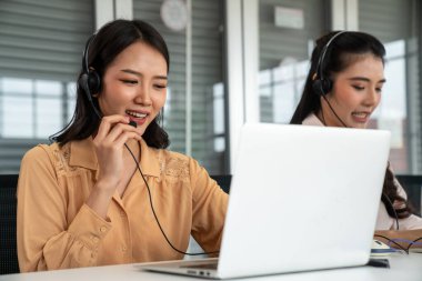 Kulaklık takan iş adamları ofiste aktif olarak çalışıyorlar.