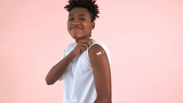 Afrikansk amerikansk tonåring visar COVID-19 vaccin bandage glatt — Stockfoto