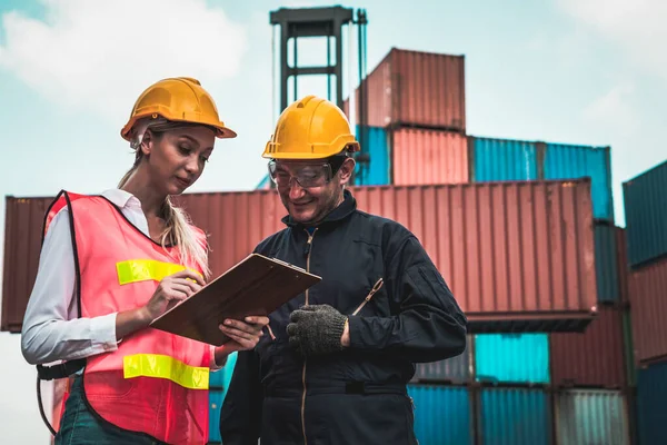 Industrial worker works with co-worker at overseas shipping container yard