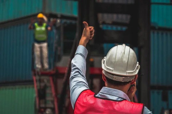 Industriële werknemer werkt samen met collega 's op buitenlandse scheepscontainerwerf — Stockfoto