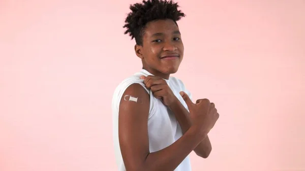 Afrikansk amerikansk tonåring visar COVID-19 vaccin bandage glatt — Stockfoto