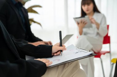 İş adamları daire içinde otururken iş projesini ustaca tartışıyor