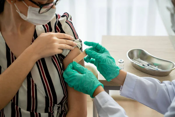 Young woman visits skillful doctor at hospital for vaccination